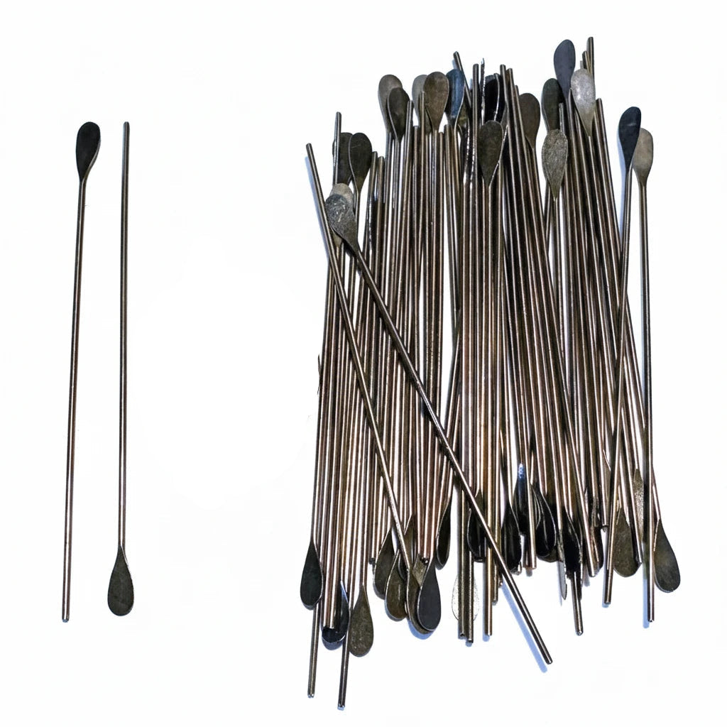 A pile of long metal picks with dark, rounded tips arranged next to two loose picks and a U.S.