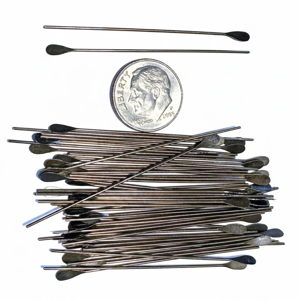 A set of long metal spoon-like tools with dark spoon heads, shown on a white background alongside a U.S.