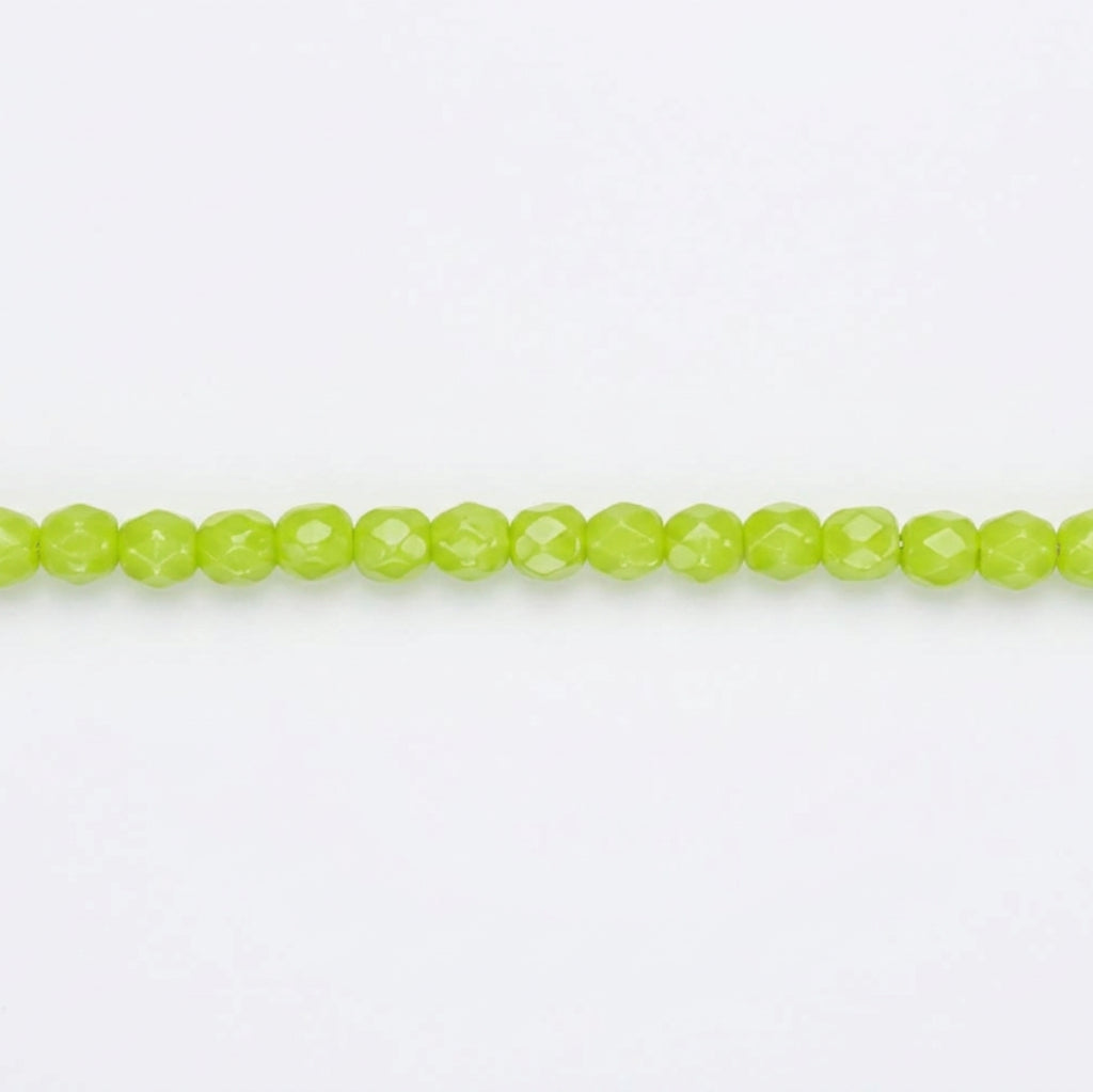 A single strand of faceted lime green beads laid horizontally on a plain white background.