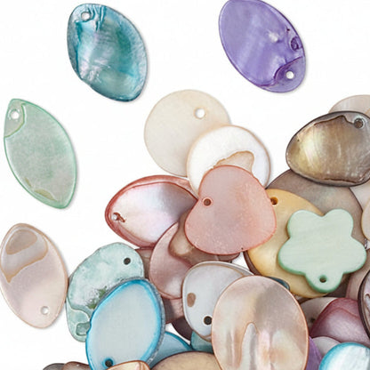 A pile of small iridescent shell-like beads or sequins in pastel and translucent colors, including pink, blue, purple, green, and cream, scattered on a white background.