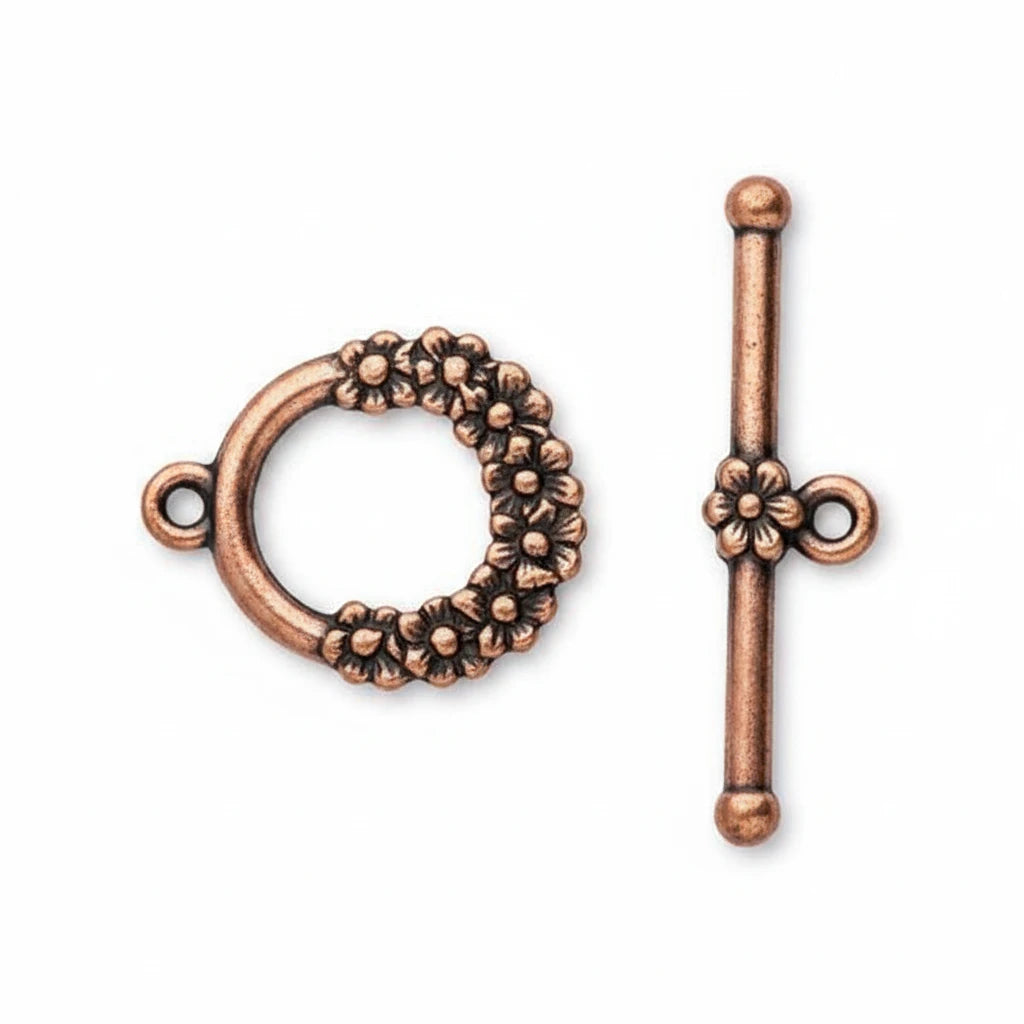 An antique bronze toggle clasp shown in two pieces: a circular ring with a textured floral border and a straight bar with a matching flower detail, displayed on a clean white background.