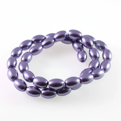 A strand of glossy, oval-shaped beads in a metallic purple color, coiled on a plain white background.