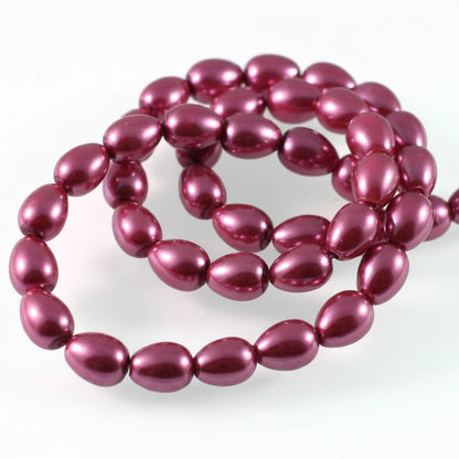 A strand of glossy, metallic plum purple beads arranged in loops on a plain white background.