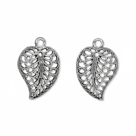 A pair of silver-toned filigree leaf-shaped charms with hanging loops, shown on a plain white background.