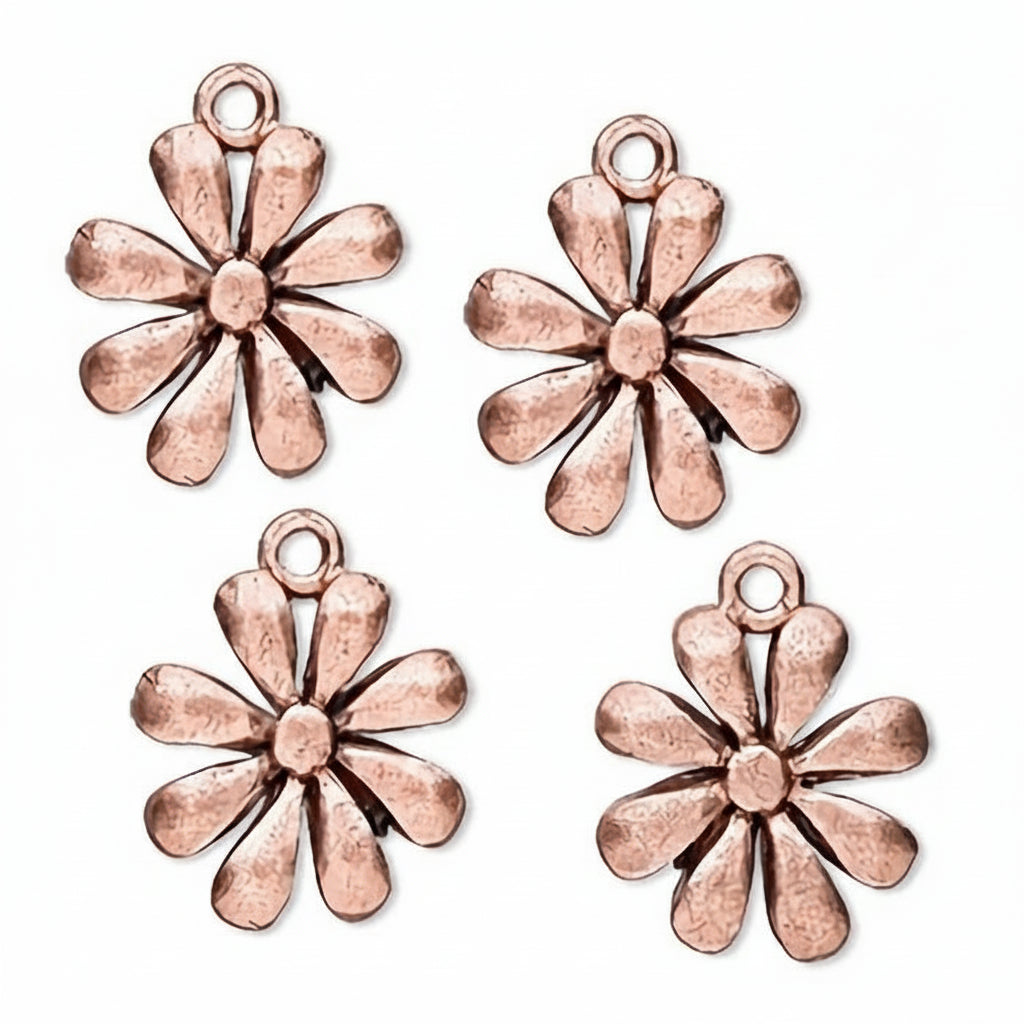 Four copper flower-shaped jewelry charms with a textured, hammered finish, arranged on a plain white background.