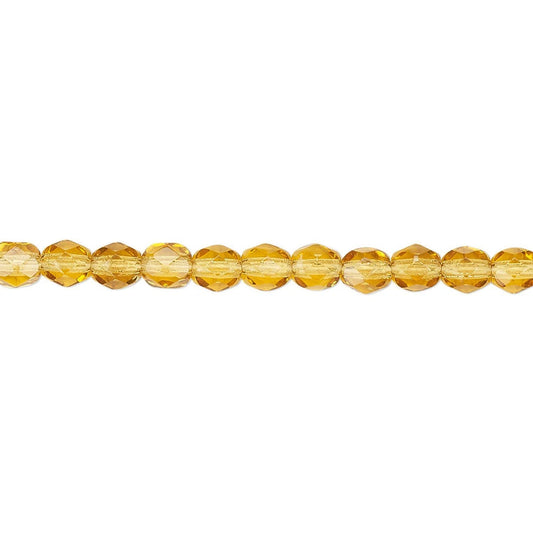 A strand of faceted amber-yellow glass beads aligned horizontally on a plain white background.