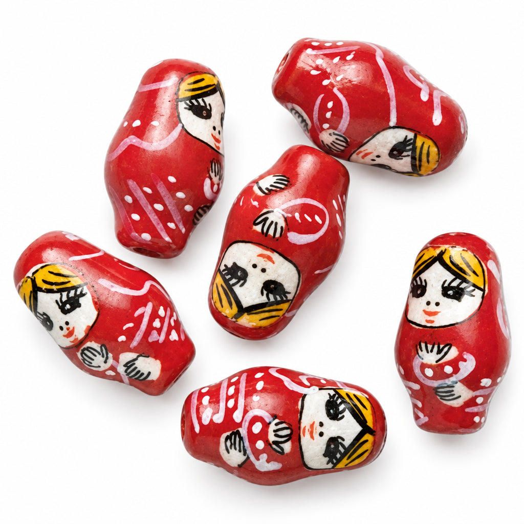 Five red ceramic Russian matryoshka doll beads with painted faces, arranged on a plain white background.