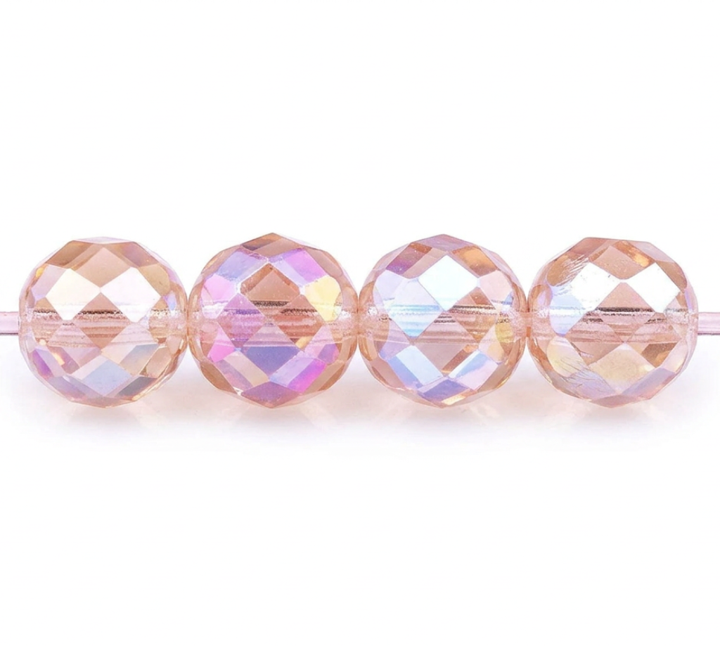 Four faceted round beads strung on a cord, featuring a pearlescent peach and iridescent lavender-blue finish against a white background.