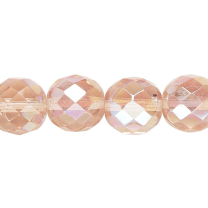 Five faceted round beads in a warm peachy-pink iridescent finish, strung on a clear cord against a plain white background.