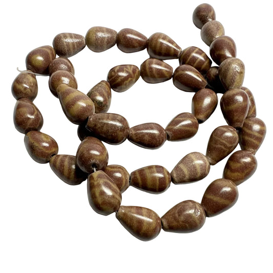 A strand of polished teardrop-shaped beads with a brown and tan striped wood-grain pattern, coiled on a light gray background.
