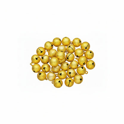 A pile of small metallic gold jingle bells with black bellies, arranged on a plain white background.