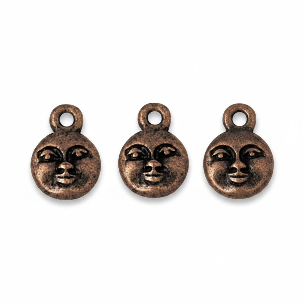 Three small round bronze-toned charms with a stylized face design and top loop, shown on a plain white background.