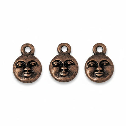 Three small round bronze-toned charms with a stylized face design and top loop, shown on a plain white background.