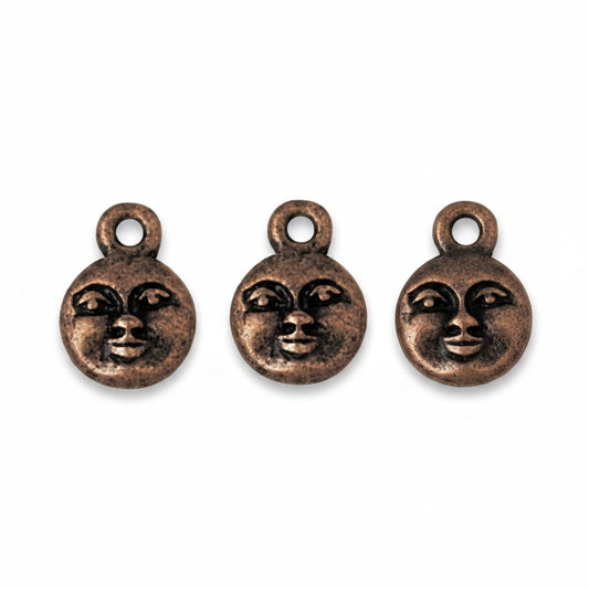 Three small round bronze-toned charms with a stylized face design and top loop, shown on a plain white background.