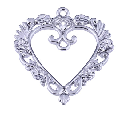 A silver heart-shaped jewelry pendant or charm with ornate filigree and floral details, shown against a white background with a ruler at the bottom indicating scale.