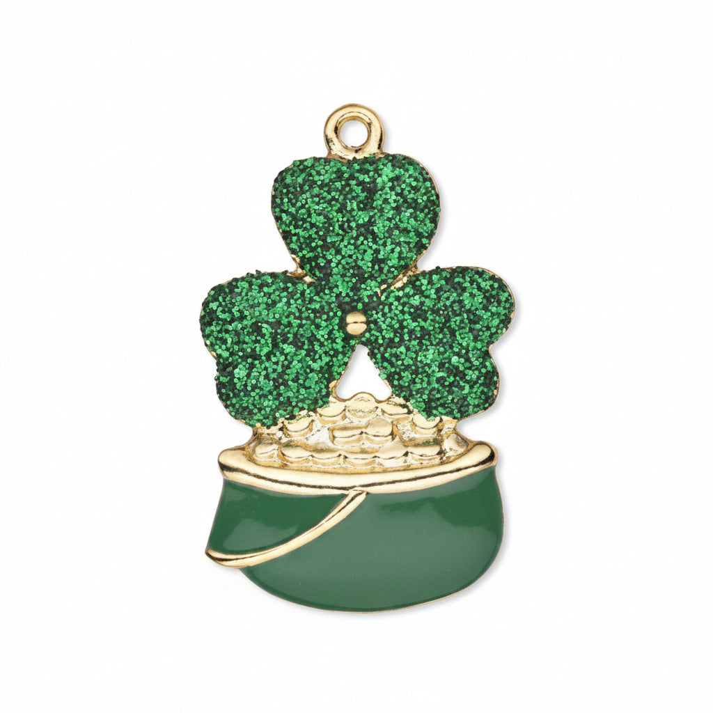 A St. Patrick's Day shamrock charm featuring a glittery green three-leaf clover on a gold-tone ring, sitting in a shiny dark green pot with gold trim and a small pile of gold coins.