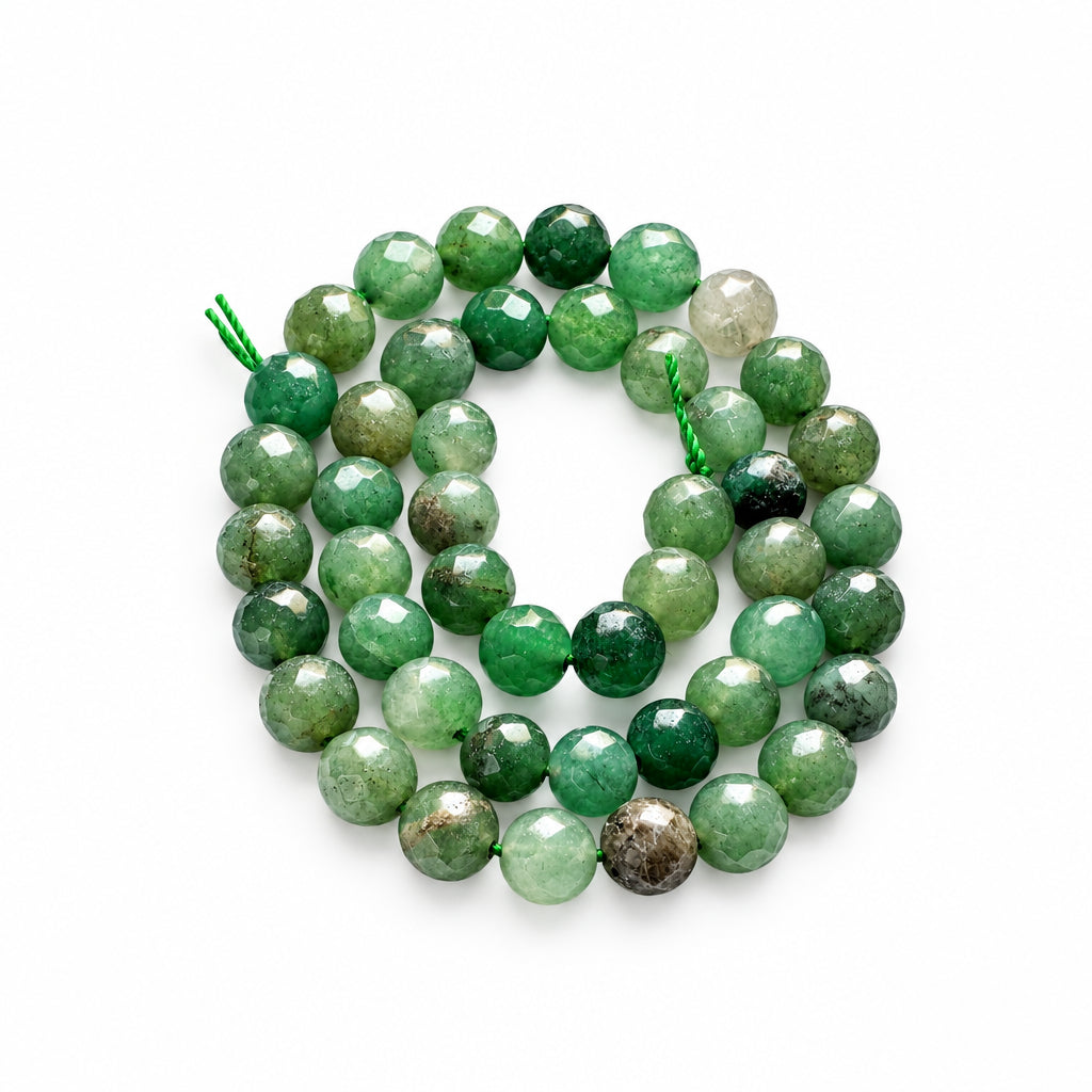 Faceted green gemstone beads strung on a cord, shown with a US quarter coin for scale on a white background.