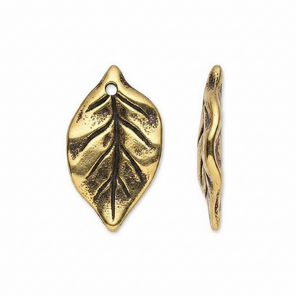 Two gold-toned metal leaf charms with textured vein details and a hanging hole, shown on a plain white background.