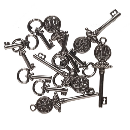 A pile of antique-style metal key charms with ornate circular medallions and decorative heads, arranged on a plain white background.
