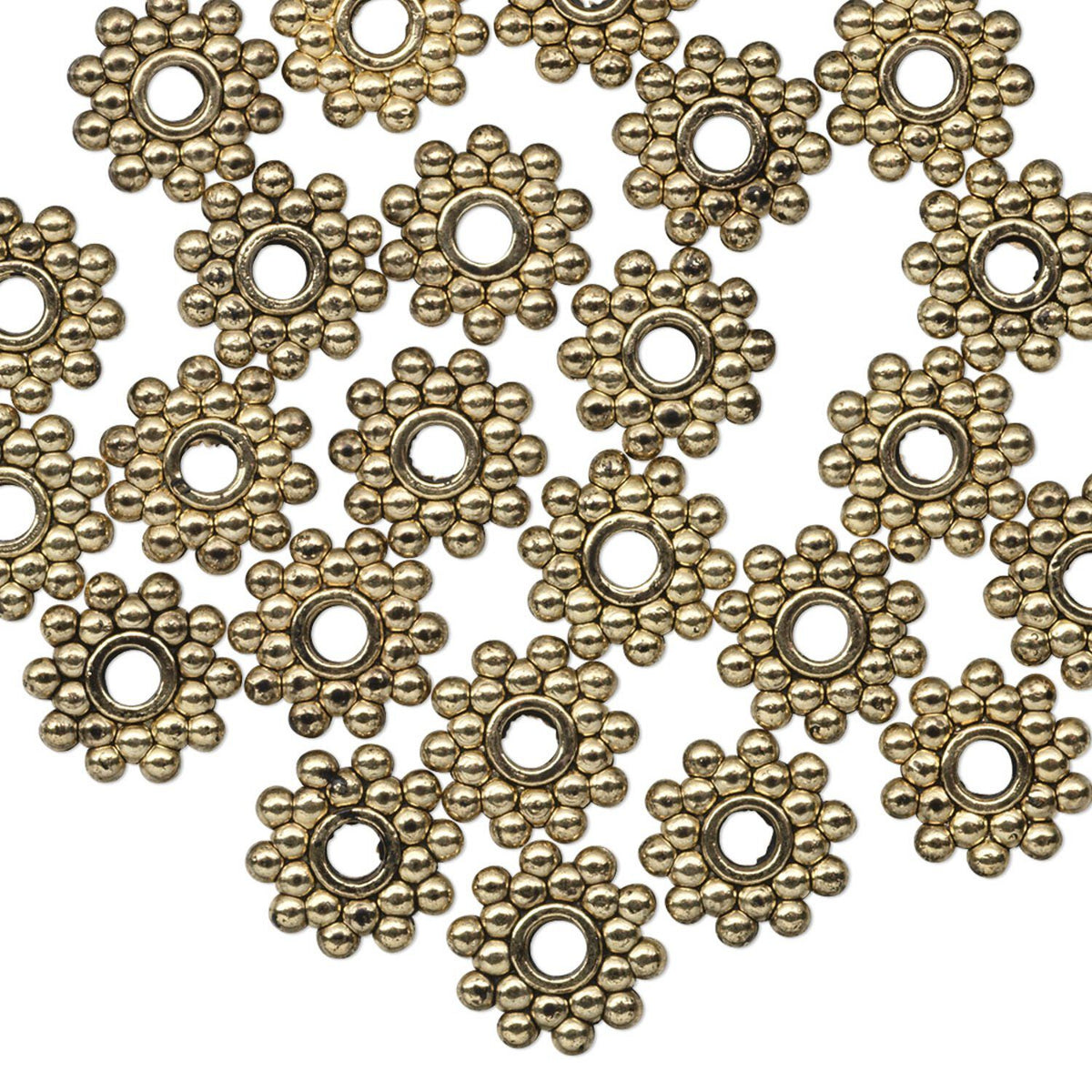 A pile of antique bronze flower-shaped metal findings with a central hole, arranged on a plain white background.