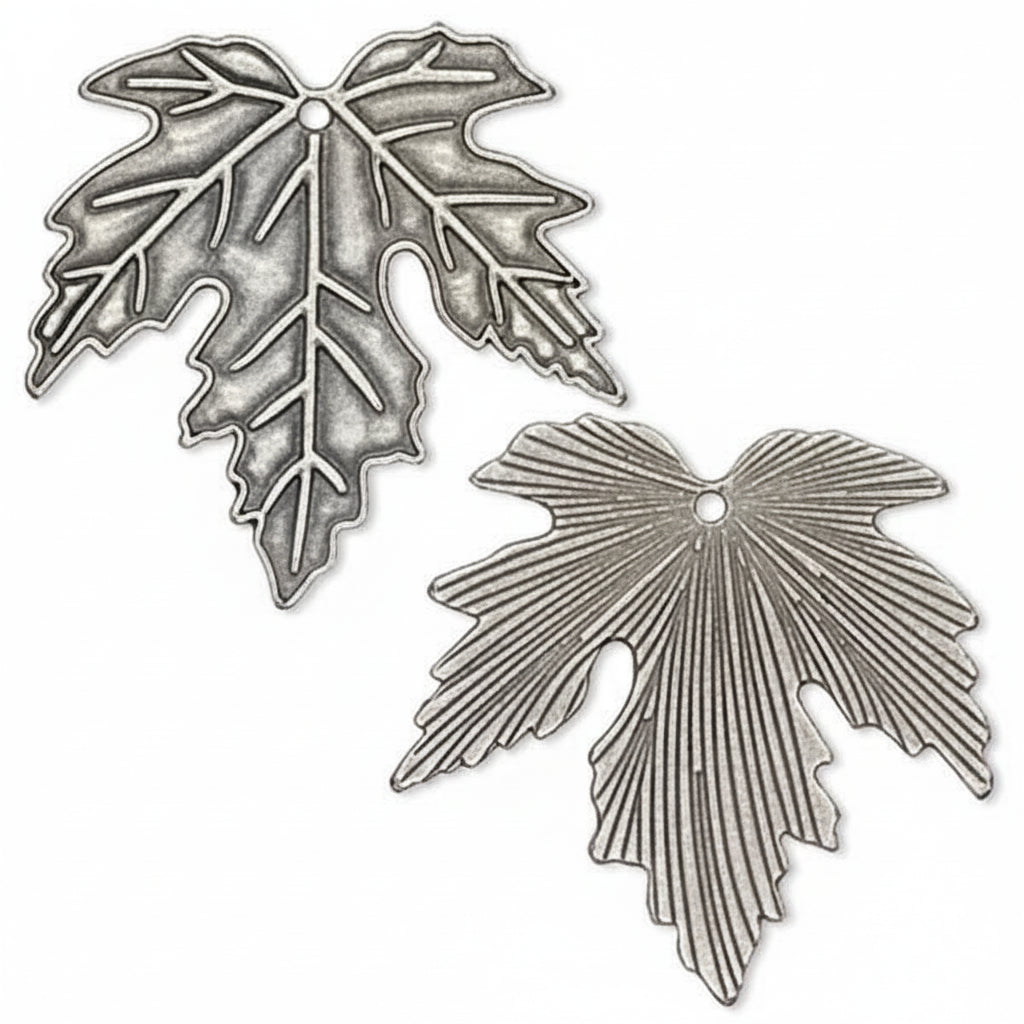 Two silver-toned metal leaf-shaped charms with textured embossed leaf details and a small hole at the top, shown on a plain white background.