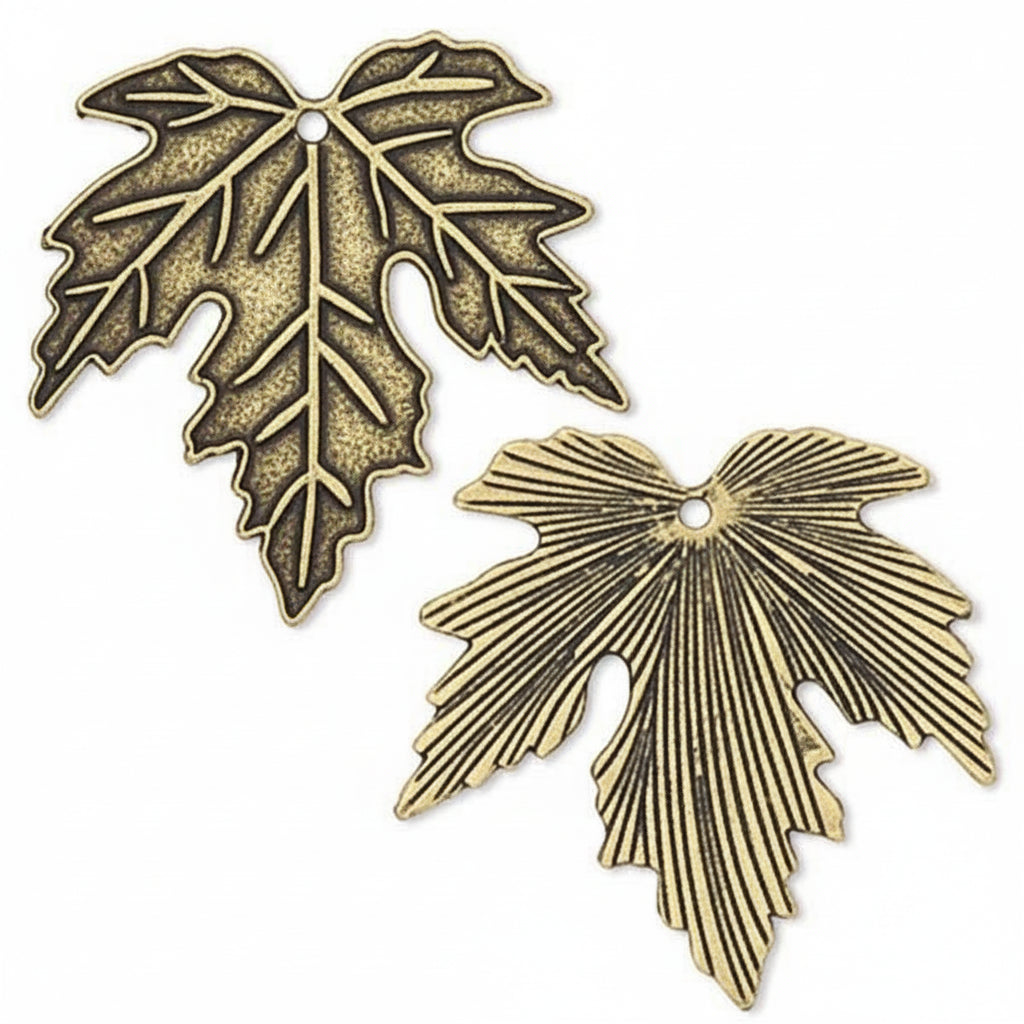 Two antique bronze metal leaf charms with detailed leaf veins and a pre-drilled hole, shown on a plain white background.