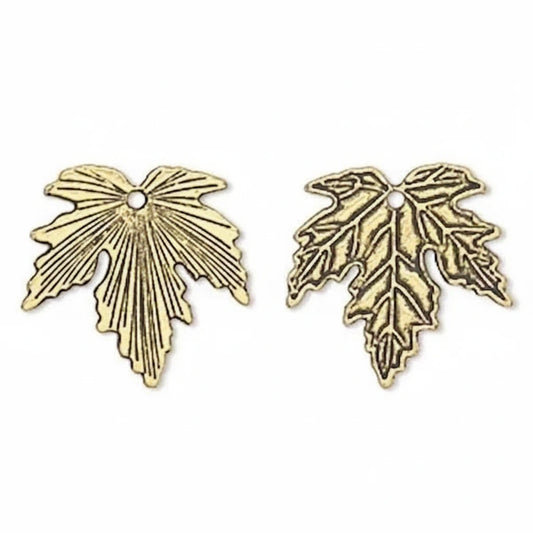 Two antique gold leaf-shaped metal charms with a small hole at the top, displayed side by side on a plain white background.