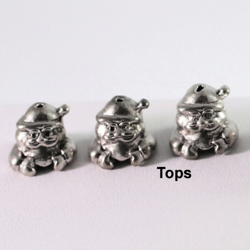 Three small silver-toned metal bead charms shaped like Santa Claus, shown on a plain light background with the word 'Tops' printed at the bottom right.
