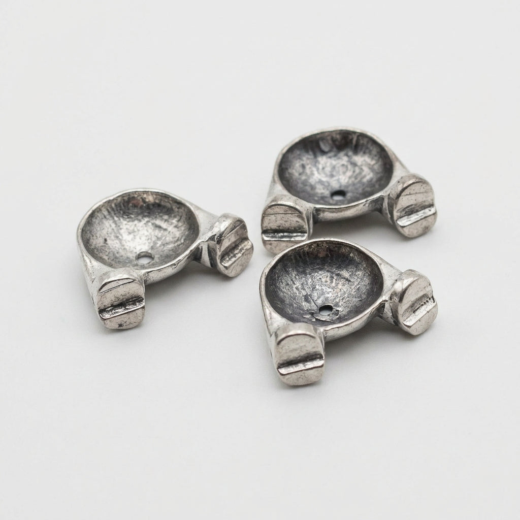 Three small metallic silver hardware pieces labeled 'Bottoms' on a plain light background.