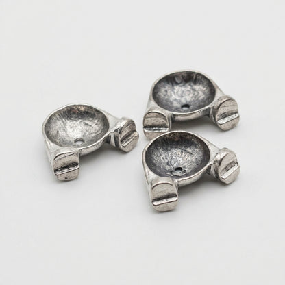 Three small metallic silver hardware pieces labeled 'Bottoms' on a plain light background.