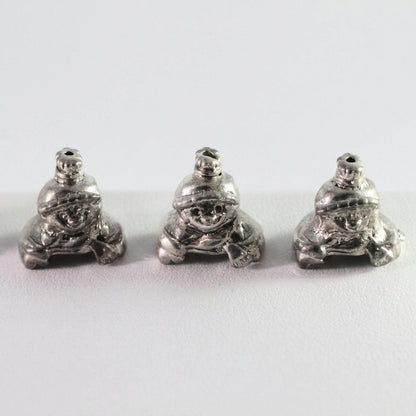 Three small silver frog-shaped beads or charms shown side by side on a plain light background.