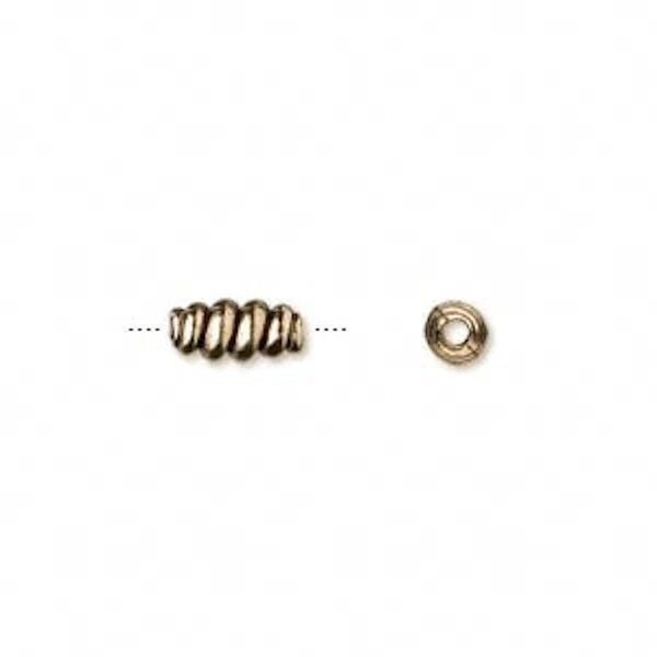 gold beads on a white reflective background.
