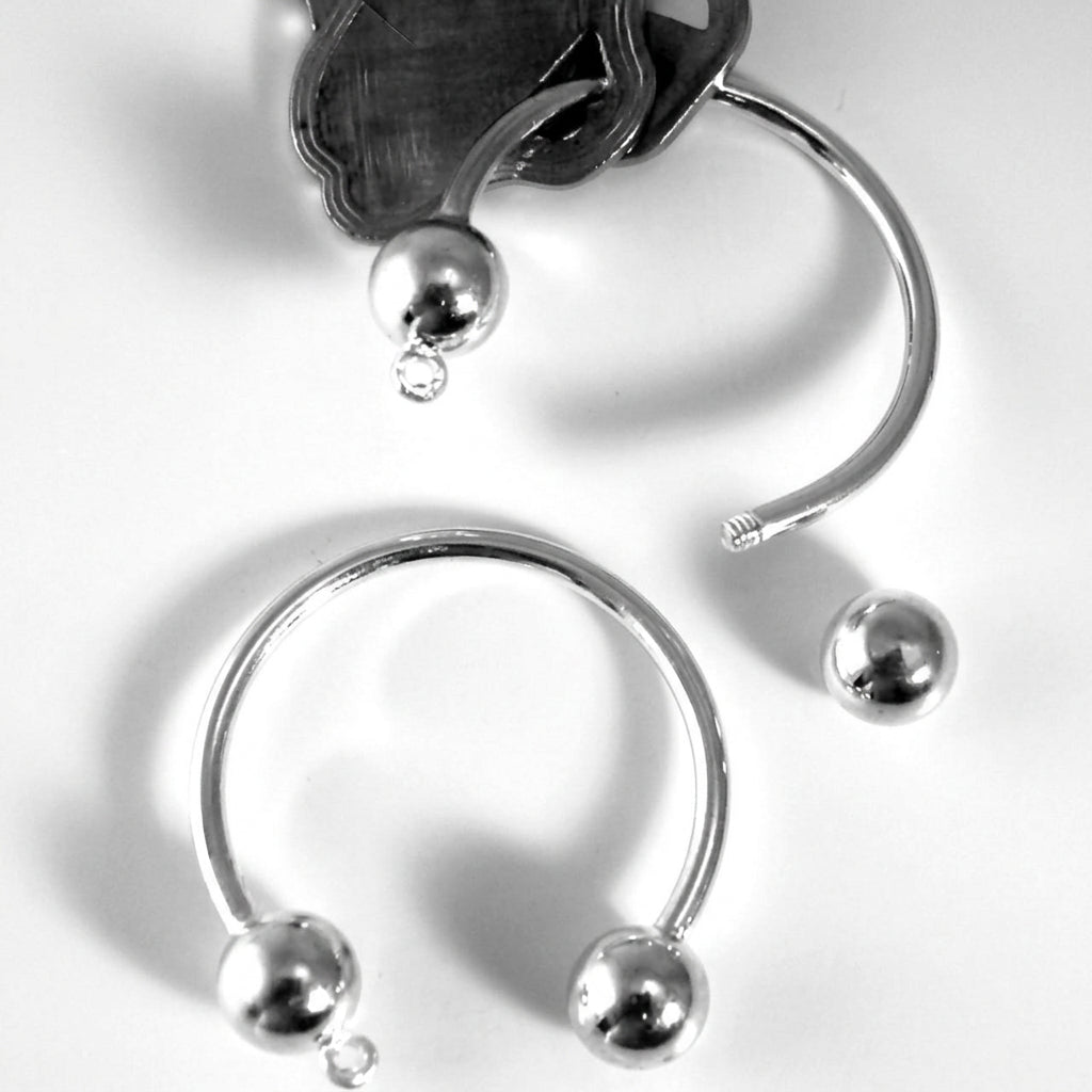 Silver-toned curved hoop with small spherical bead details at the ends, shown on a white background 