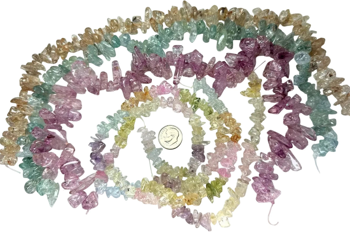 Three strands of multicolor raw crystal chip beads arranged in loops on a white background, with a coin in the center for scale.