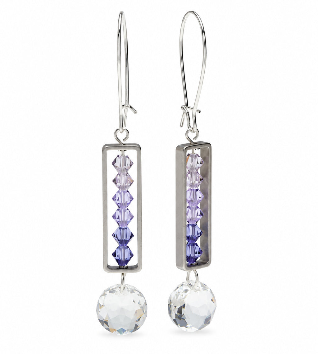 Silver-toned drop earrings with rectangular bezel settings holding four faceted lavender beads, finished with a large clear crystal pendant and fishhook wires. A small '*Sample Only' note appears below.