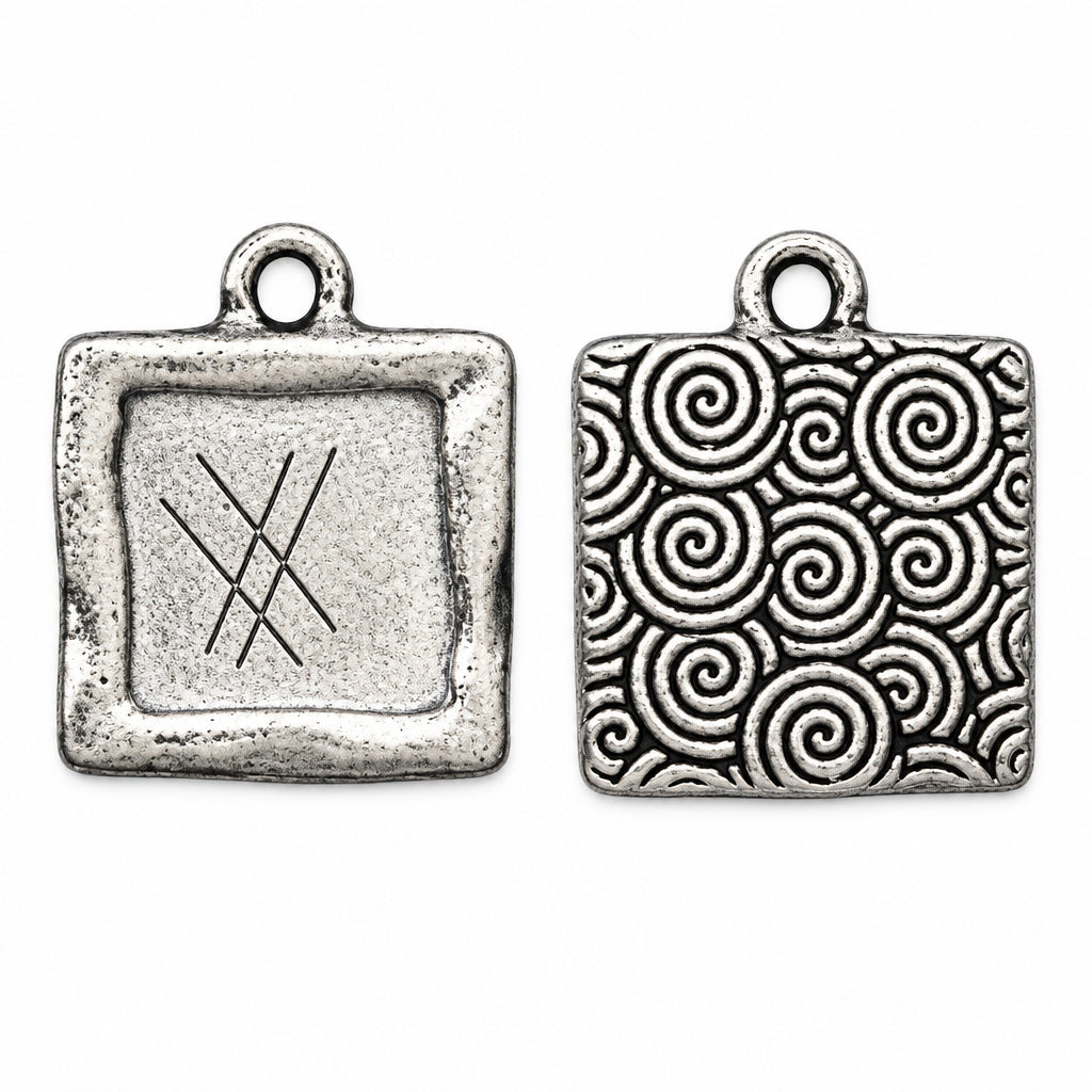 Two silver square charms with rounded corners on a white background. The left charm shows a simple engraved symbol, while the right charm features an intricate pattern of interlocking spirals.