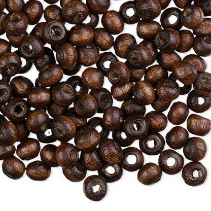 Dark brown wooden seed beads with hollow centers, scattered on a plain white background.