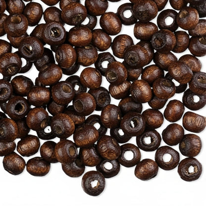 Dark brown wooden beads with hollow centers, scattered on a plain white background.