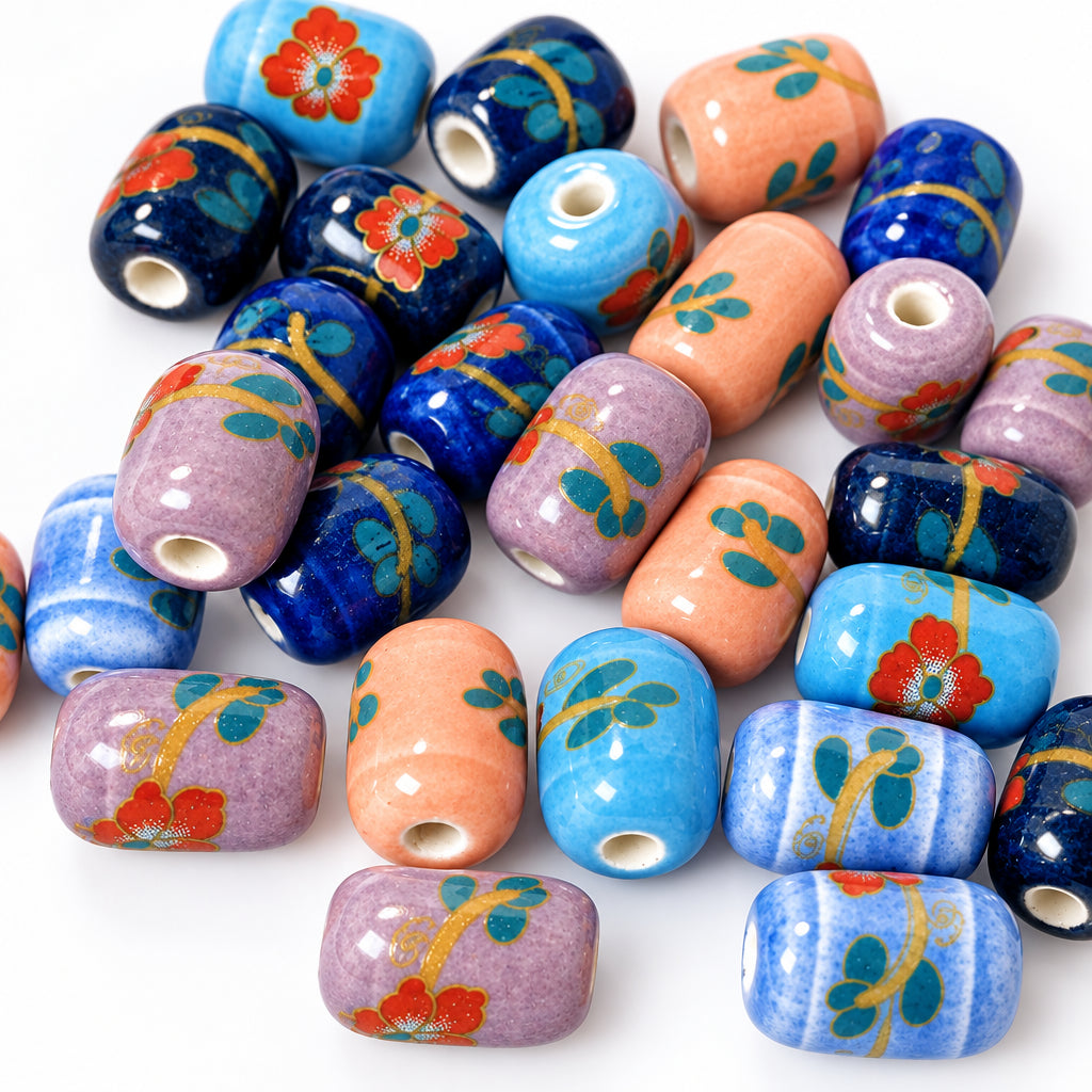 A close-up pile of handmade glass bead charms with a glossy finish, featuring various colors and floral patterns including blue, purple, orange, black, and red.
