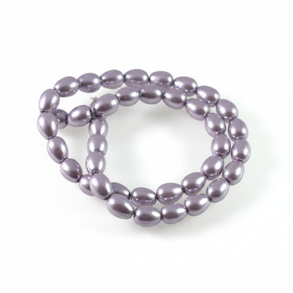 A strand of glossy, oval-shaped lavender beads arranged in a loop on a plain white background.