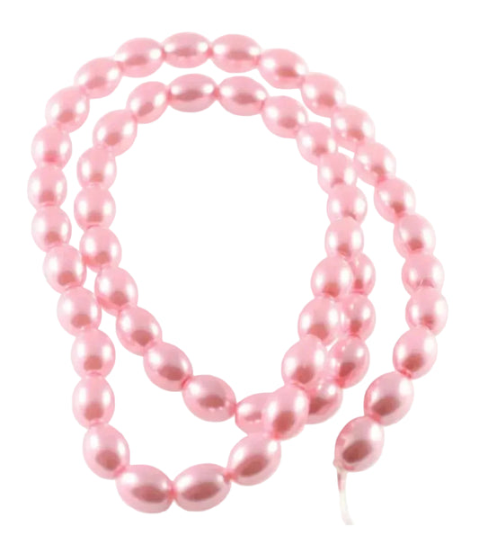 A strand of glossy, light pink faux pearl beads arranged in loops on a plain white background.