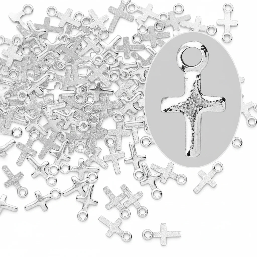 Silver cross-shaped jewelry charms with hanging loops, shown scattered on a dark gray background with a magnified inset of one charm.