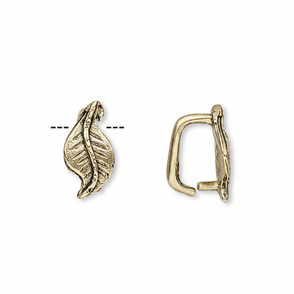 A pair of gold-toned metal ear cuffs shown on a plain white background, one displaying the front leaf-like design and the other showing the side profile.