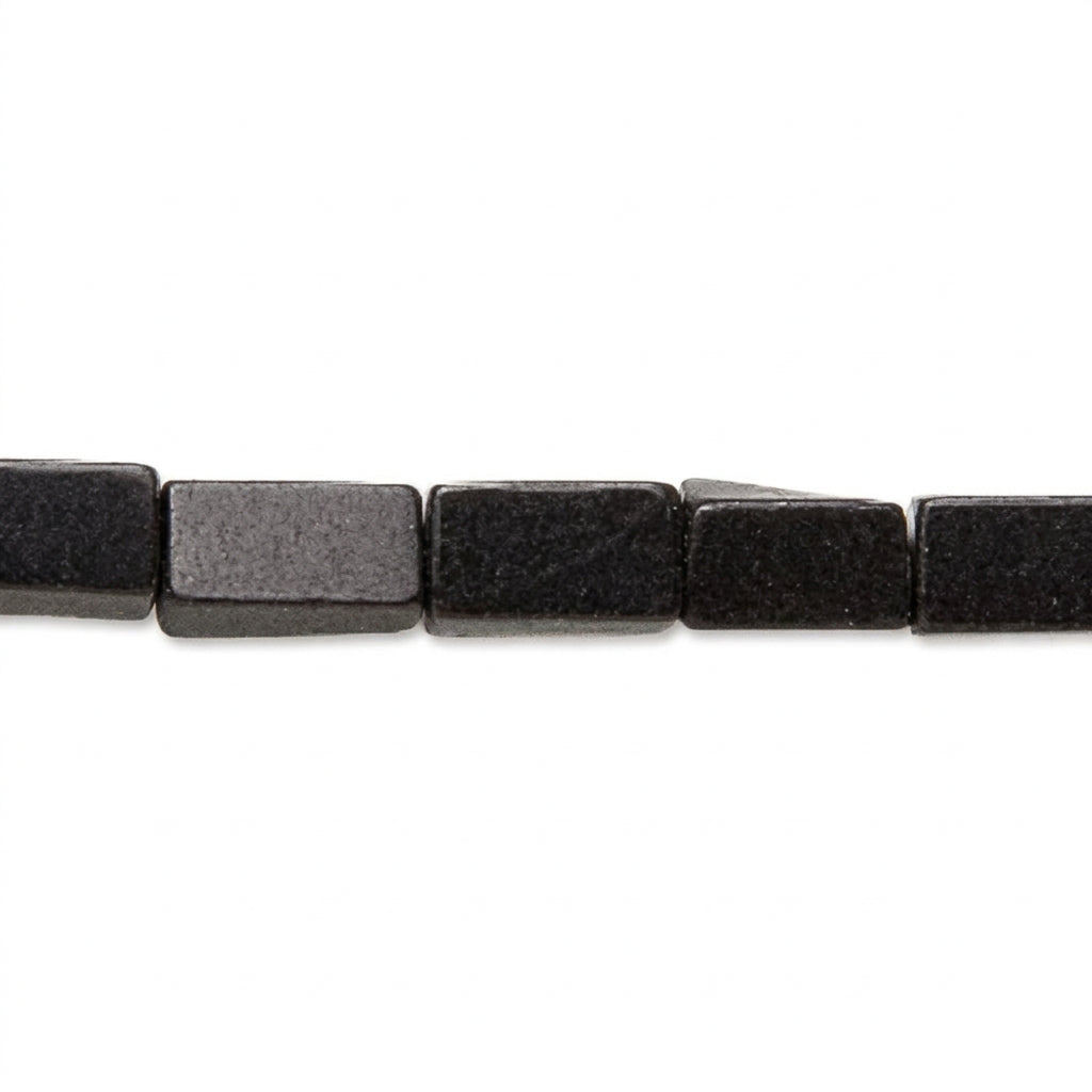 A close-up of a strand of rectangular black beads with a matte, slightly textured finish, shown against a plain white background.