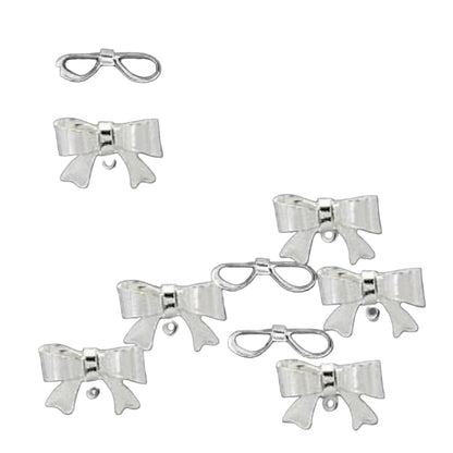 Six white satin ribbon bows with silver metal wire loops and pearl centers, arranged on a solid dark gray background.