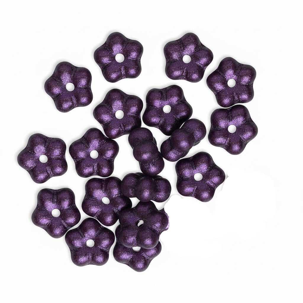 A group of small metallic lavender-purple flower-shaped beads with a central hole, arranged on a plain white background.