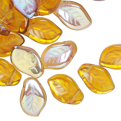 A cluster of translucent amber-yellow glass beads with a leaf vein pattern, some showing a pearlescent iridescent finish, scattered on a plain white background.