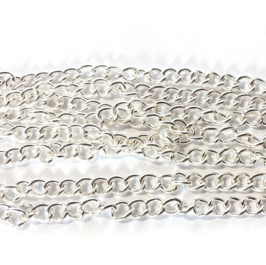 A close-up of a silver-toned metal chain made of interlocking oval links, arranged in horizontal rows on a white textured background.