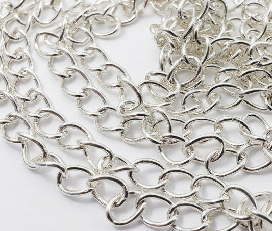 A close-up of a silver-toned metal link chain draped across a white background.