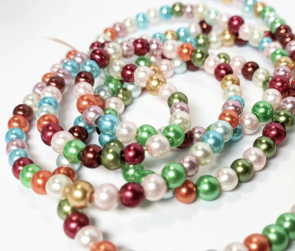 Multicolor faux pearl bead garland strands on a white background.